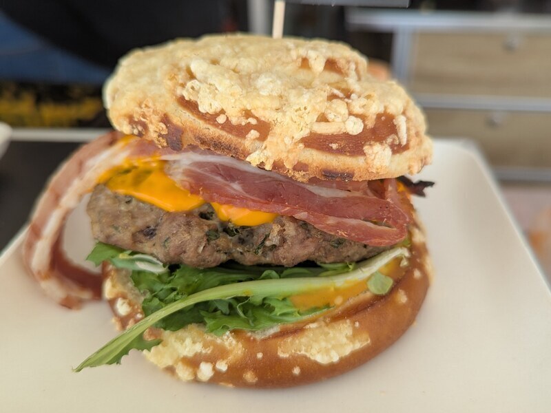 Burger mit Schinken, Rucola und Spiegelei im überbackenen Käse-Bun