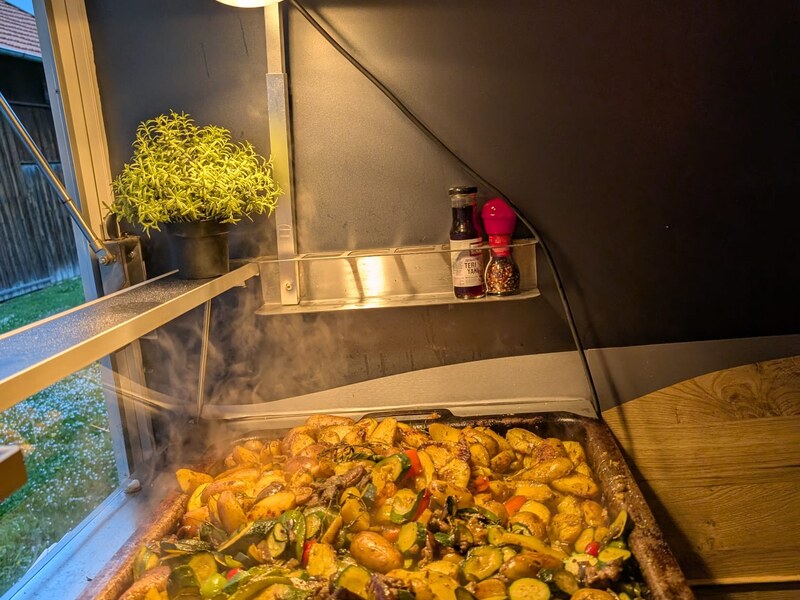 Frisch gebratenes Gemüse in einer großen Pfanne, aufsteigender Dampf im Foodtrailer