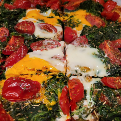 Ofenfrische Pizza mit Tomaten, Spinat und Ei in Nahaufnahme